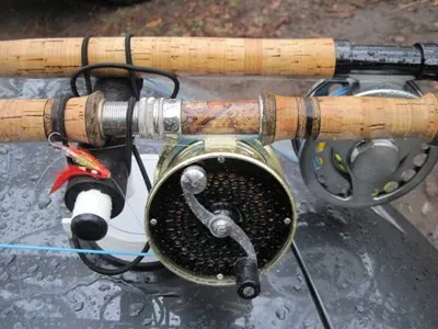 Cork handled Spey rods and fly reels laid on a car boot with a salmon fly attached