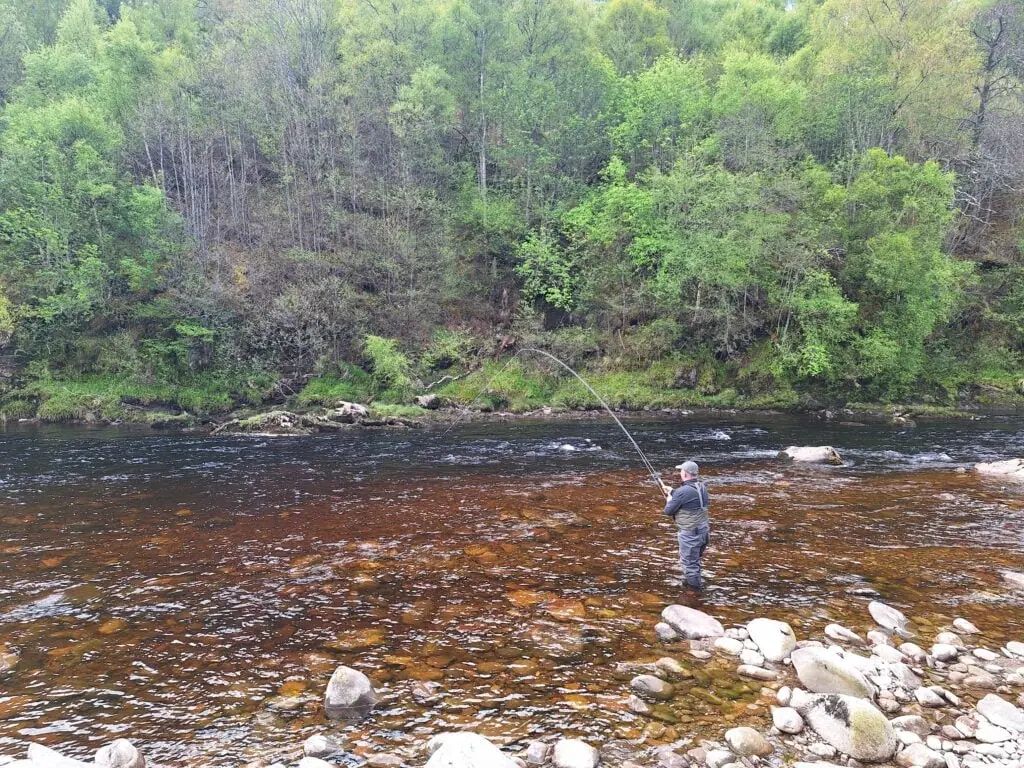 Playing a salmon on a double handed Spey rod at Drynachan on the River Findhorn